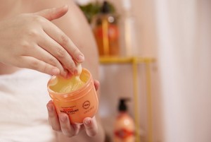 Hand scooping The Body Shop Mango Body Yogurt